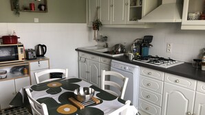 A compact kitchen with white cabinets, a microwave, toaster, and a gas stove.
