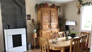 A dining area with a wooden table, chairs, and a cabinet with decorative flowers.