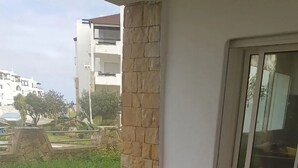 Un comedor con una mesa larga, cuatro sillas y un pilar de piedra.