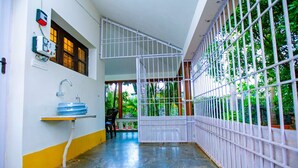 A room with a sink, window, and a view of greenery through a barred window. - Queens Paradise Estate (Vanur)
