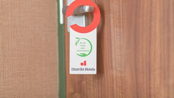 A door with a metal handle and a sign indicating 'do not clean safe environment' for District Hotels.