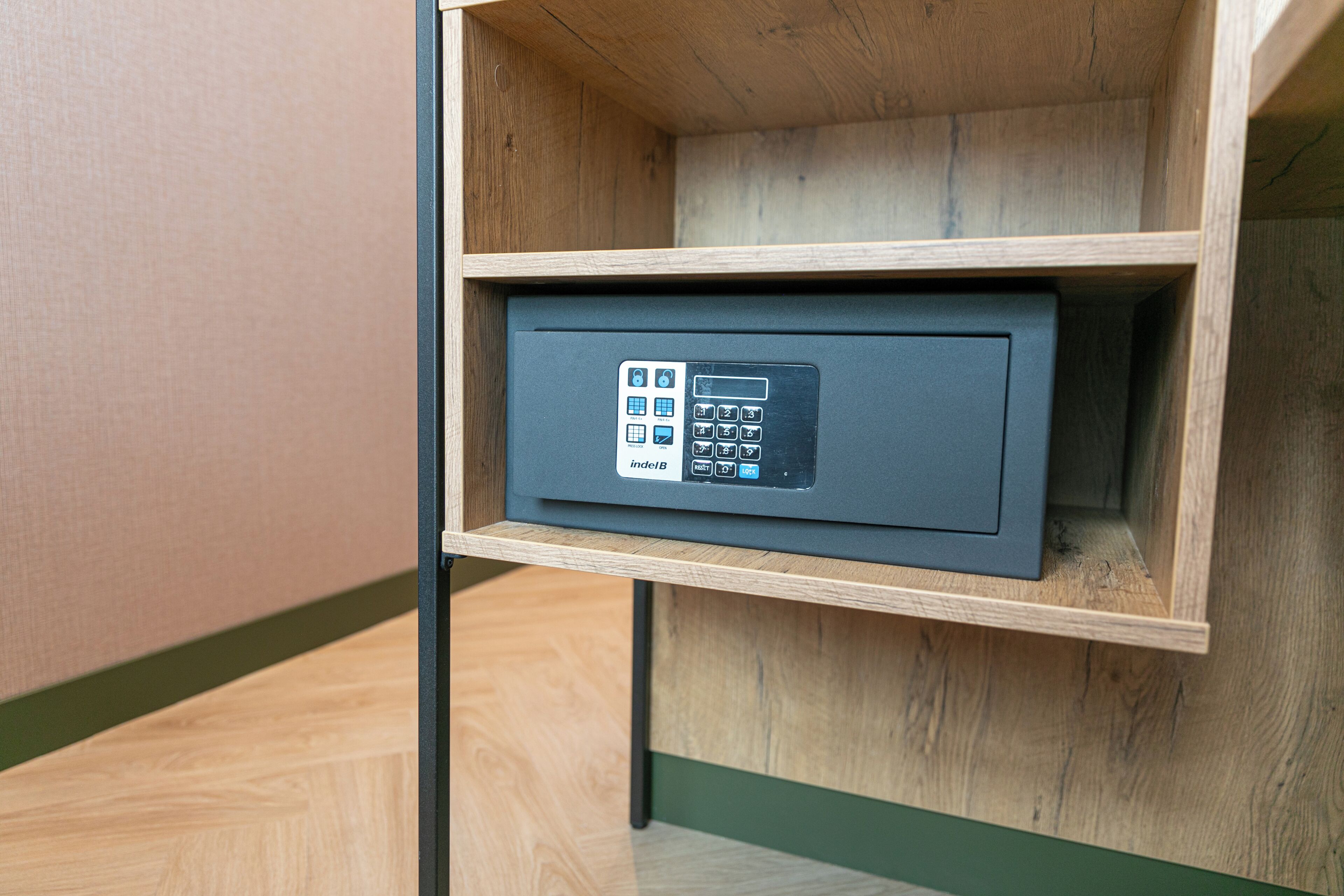 A secure storage unit with a keypad lock, placed in a wooden cabinet.