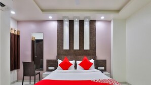 Een moderne hotelkamer met een groot bed, een spiegel, een bureau en een stoel.