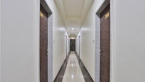 Een lange, smalle hotelgang met deuren aan beide kanten, elk voorzien van een nummer.