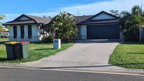 A two-story house with a garage, a driveway, and a mailbox. - Gladstone Super Home Fully Fenced With Central Aircondioning (New Auckland)