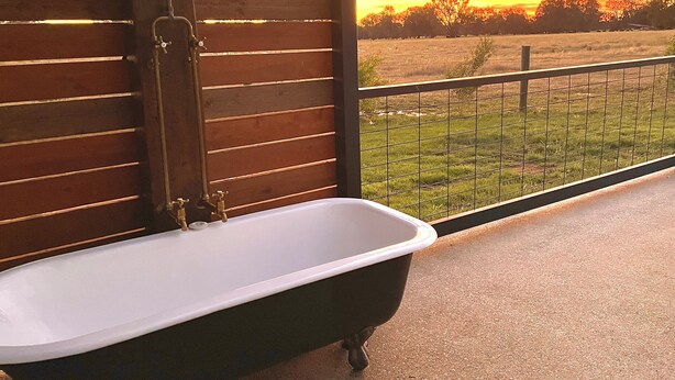 A bathroom with a bathtub, wooden slats, and a view of a field at sunset. - Peaceful & Picturesque Farm Stay Only 5 Mins Drive From Benalla Township (Benalla)