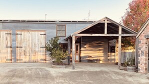 A building with two large wooden doors, a covered porch, and a brick section. - Peaceful & Picturesque Farm Stay Only 5 Mins Drive From Benalla Township (Benalla)