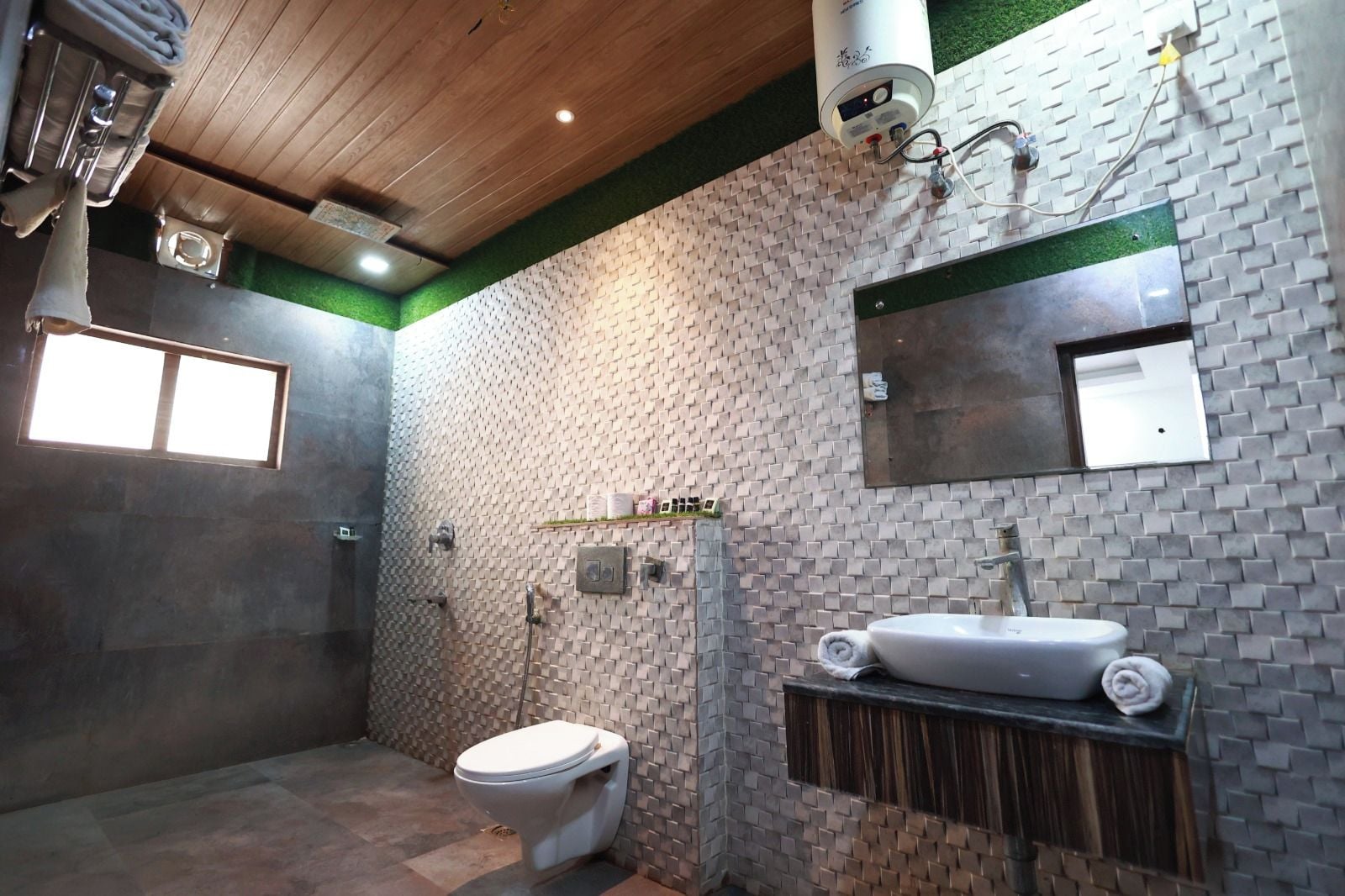 A bathroom with a modern design, including a toilet, sink, and shower area.