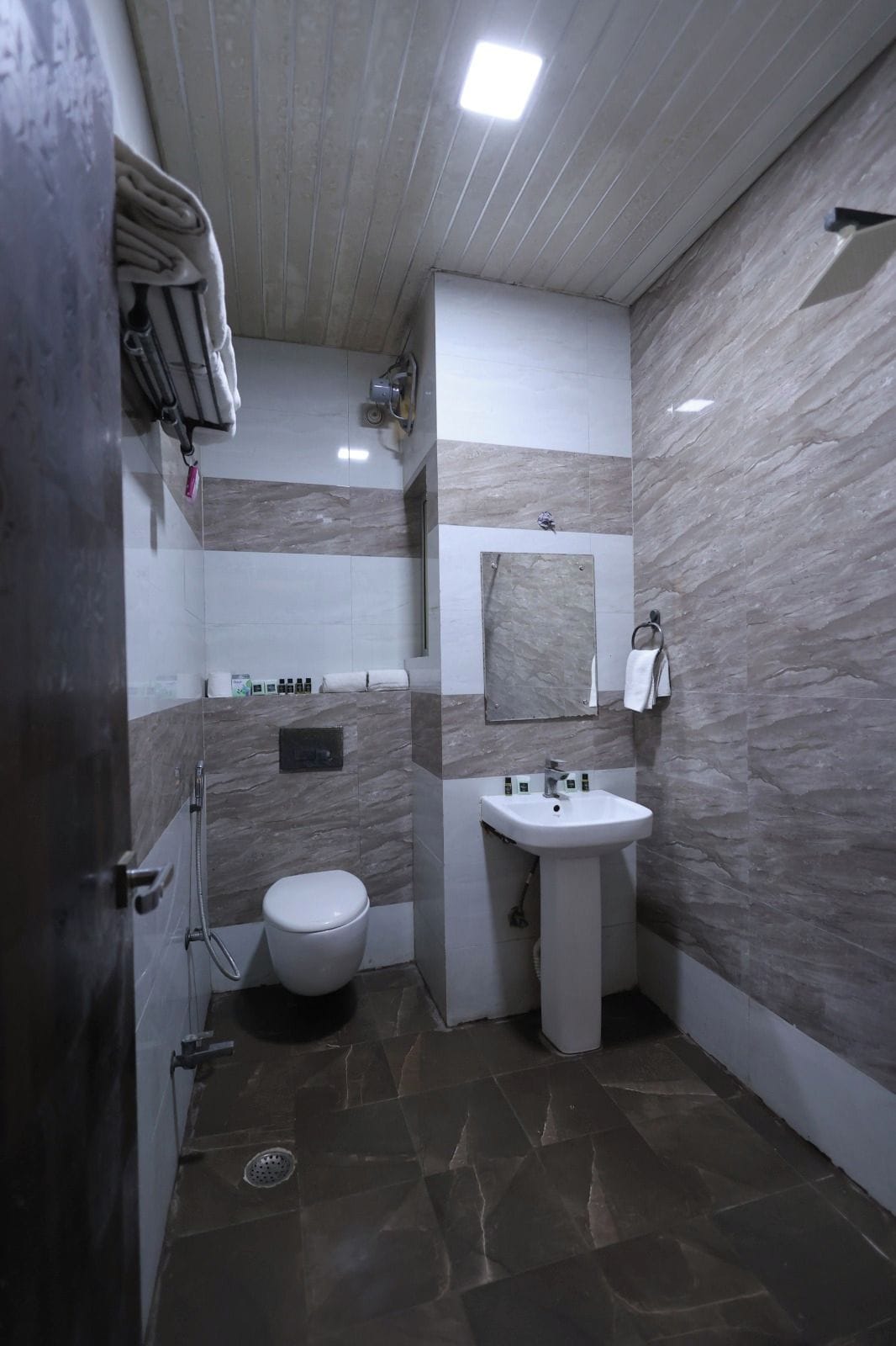 A bathroom with a toilet, sink, and shower area.