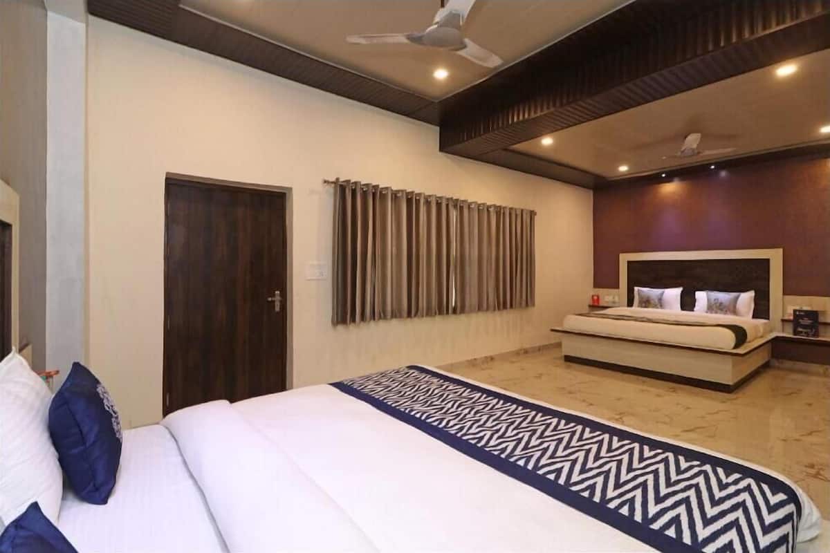 A modern hotel room with a large bed, a bedside table, a headboard, and a ceiling fan.