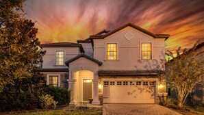 A two-story house with a garage, a front entrance with a door, and a driveway. - "Enchanted Escape" - Game Room|Massage Chairs|Peloton Bike|Sleeps 23 (Davenport)
