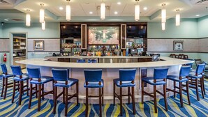 A bar area with a curved counter, multiple bar stools, and overhead lighting. - "Enchanted Escape" - Game Room|Massage Chairs|Peloton Bike|Sleeps 23 (Davenport)