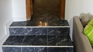 A hallway with marble stairs leading to a bedroom with a bed and a nightstand. - Claudia Puertito de Adeje - 1 bedroom, 70sqm, on the beach (CN)
