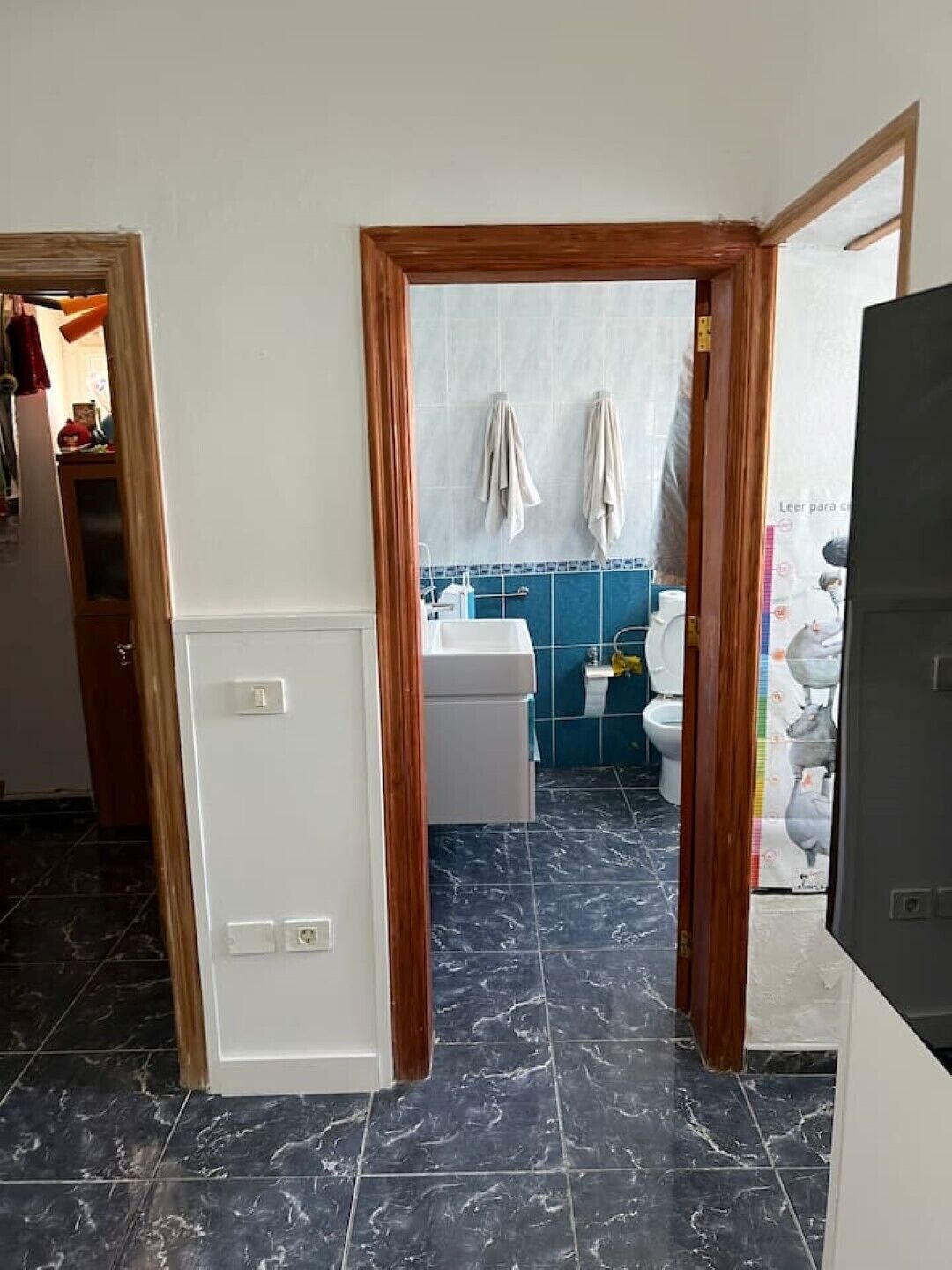 Un baño con un lavamanos blanco, azulejos azules y un inodoro.