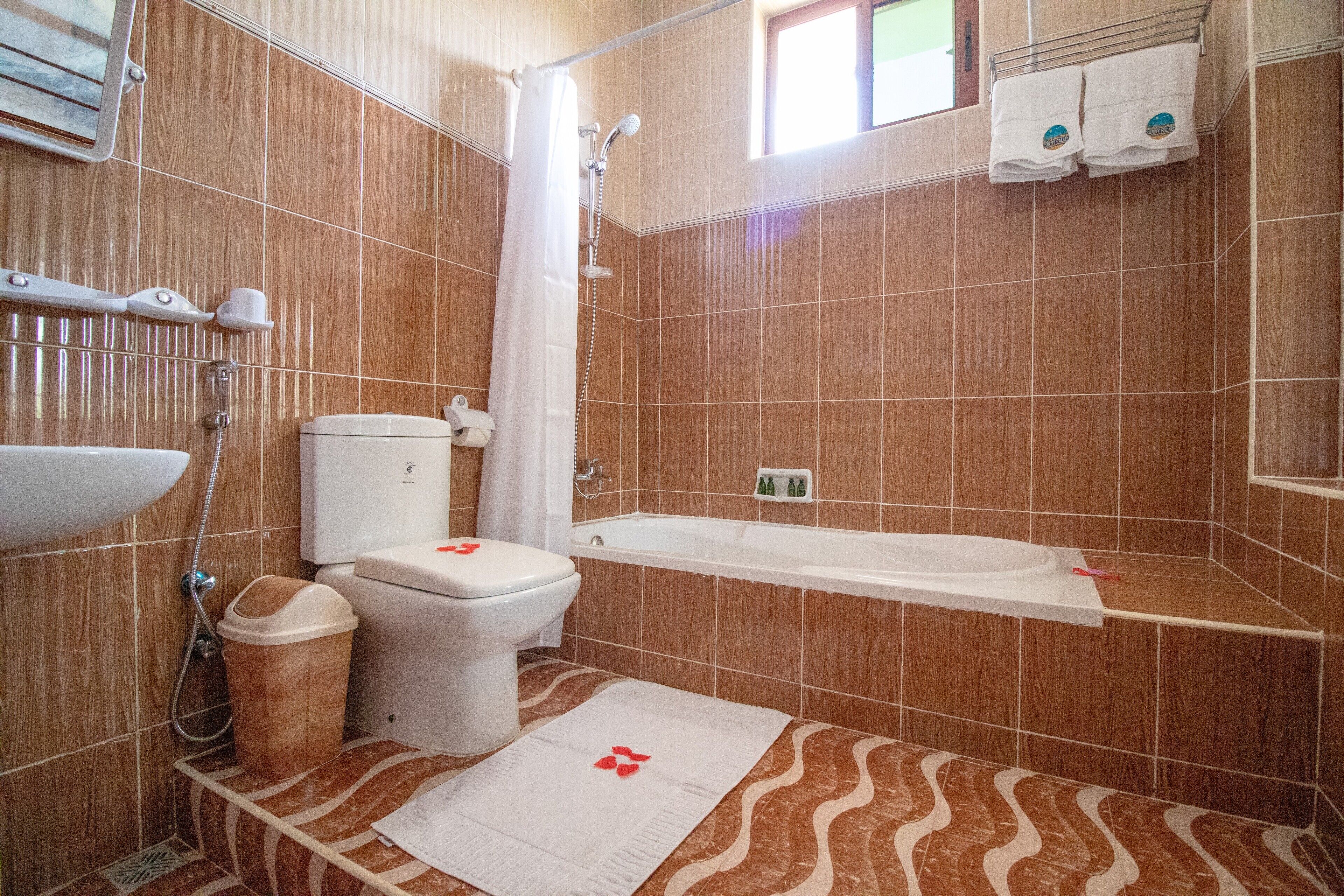 Une salle de bain avec douche, toilettes et baignoire.