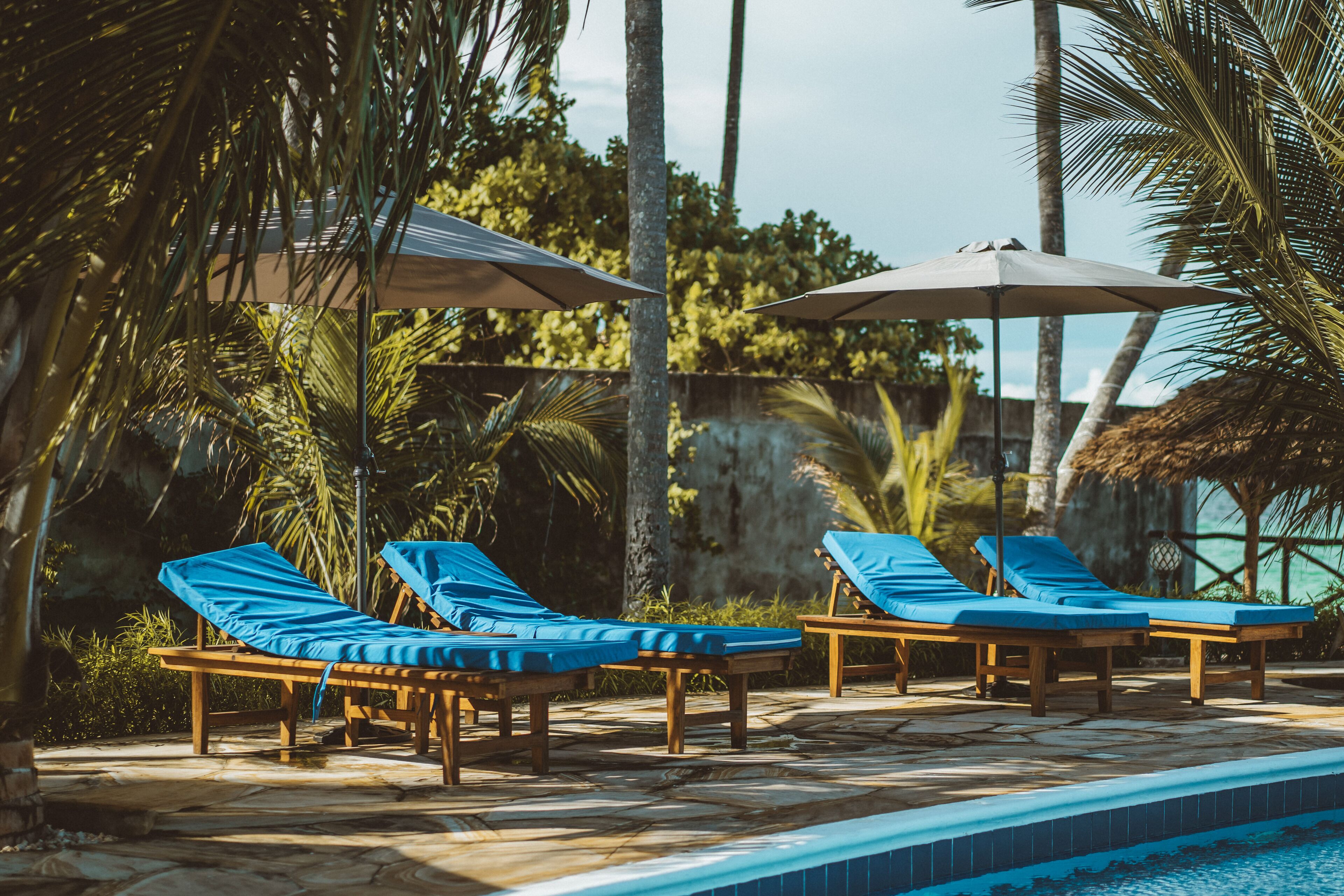 A poolside area with lounge chairs and umbrellas.