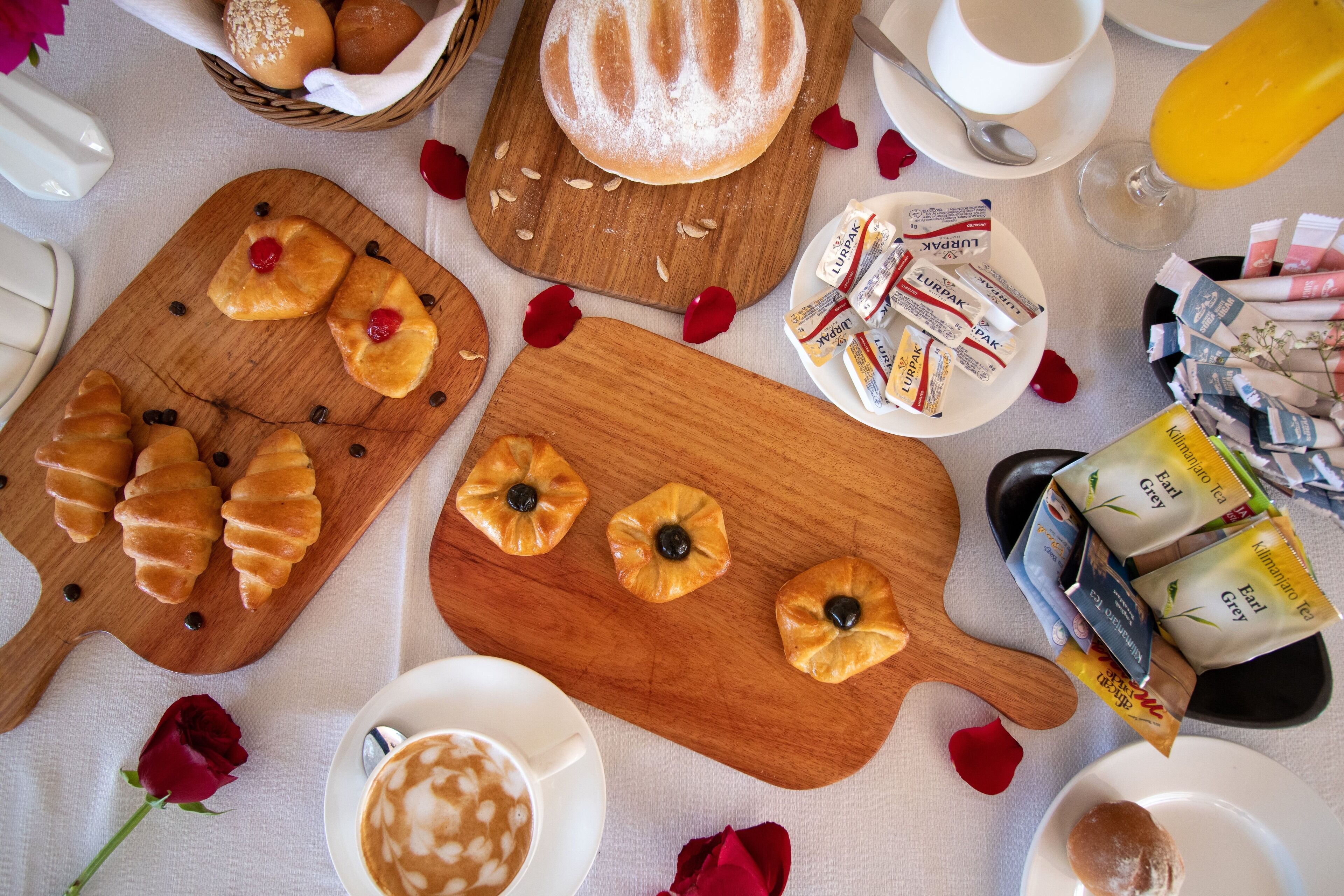 Un desayuno con pasteles, café y té sobre una mesa.