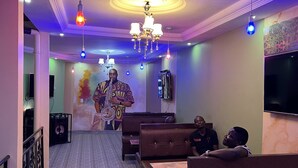 Een restaurant met een modern interieur, met een grote muurschildering, meerdere zithoeken en verschillende soorten verlichting.