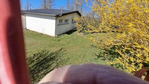 A house with a sloped roof, a small porch, and a grassy yard. - Le Paradis de Marie (Treignac)