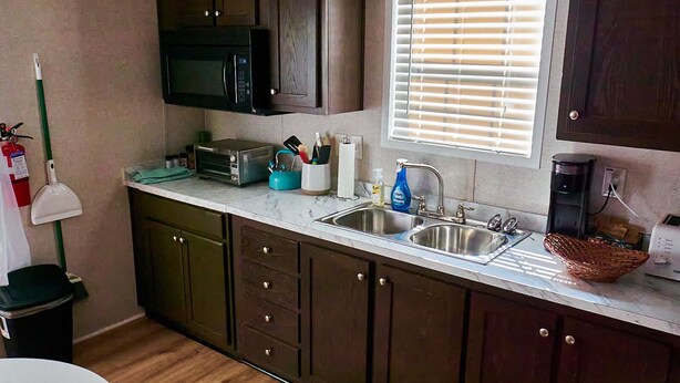 A compact kitchen with dark wooden cabinets, a microwave, a toaster, and a sink. - Private, detached 1 bedroom apt. 6 miles from Folly Beach & downtown Charleston (Charleston)