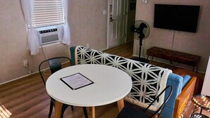A small dining area with a round table, a menu, and a patterned bench. - Private, detached 1 bedroom apt. 6 miles from Folly Beach & downtown Charleston (Charleston)