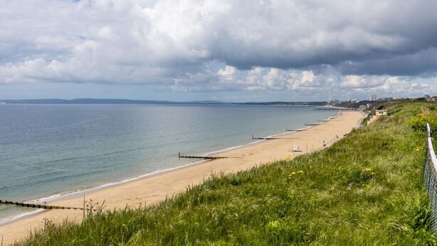 A coastal beach with a grassy foreground and a clear view of the sea. - Modern 2bed Flat, Parking, Close to Beach & Shops (Bournemouth)