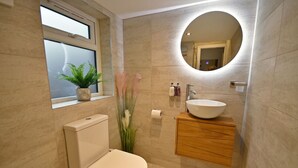 Une salle de bain moderne équipée de toilettes, d’un lavabo et d’un meuble-lavabo.