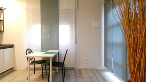 A small, modern kitchen with a white countertop and two black chairs. There is a window with a view of the outside. - BuenRetiroPe_Ita - Comfortable two-room apartments with garden (Pescara)