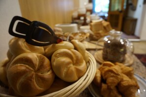 A breakfast buffet with various breads and pastries.