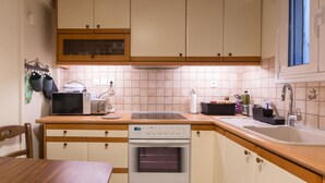 A kitchen with wooden cabinets, a built-in oven, a sink, and a window. - Tati's Parthenon apt 2bdr/1,5bthr/100Mbps VDSL- 5mins walk to Acropolis (Αθήνα)