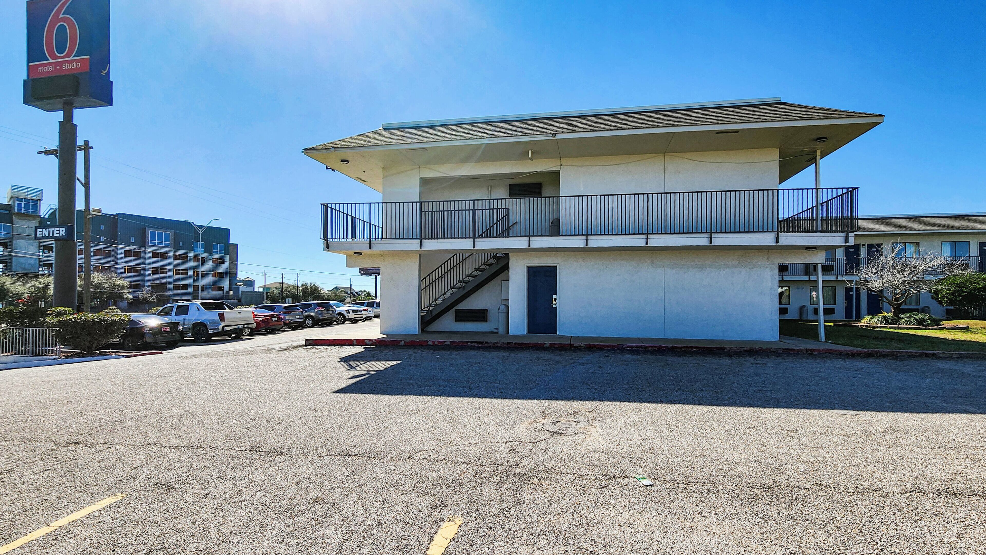 Un motel con una estructura de dos pisos, un balcón en el piso superior y una entrada visible.