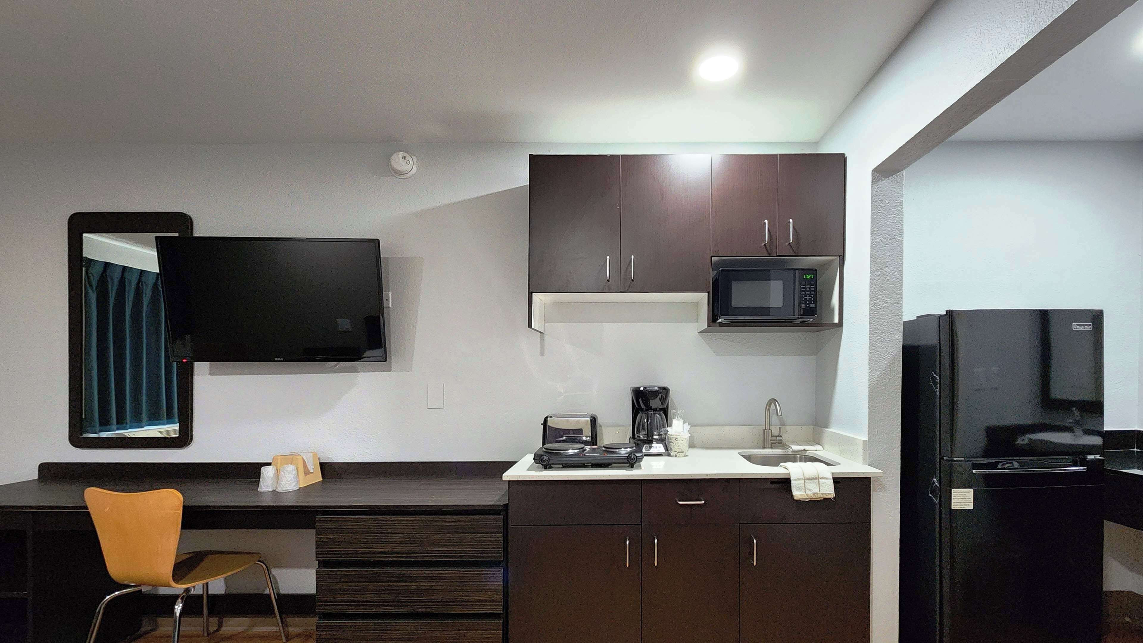A compact kitchen with a microwave, coffee maker, and a small refrigerator.