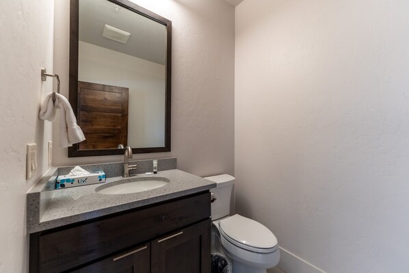 A bathroom with a sink, mirror, and toilet.