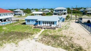 Une propriété située sur la côte, comprenant une grande maison, une piscine et un espace de plage.