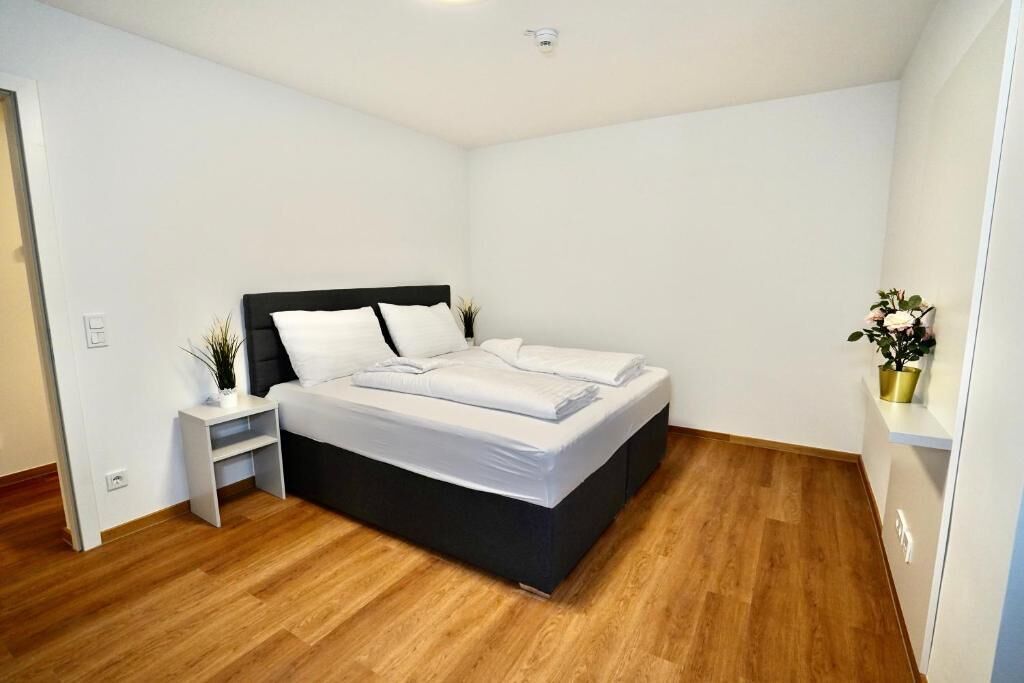 Une chambre à coucher avec un lit, des tables de chevet et une plante en pot.