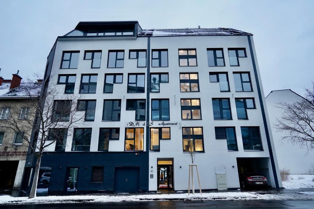 Un immeuble à plusieurs étages, sur lequel on peut voir une enseigne indiquant qu’il s’agit d’un ensemble d’appartements.