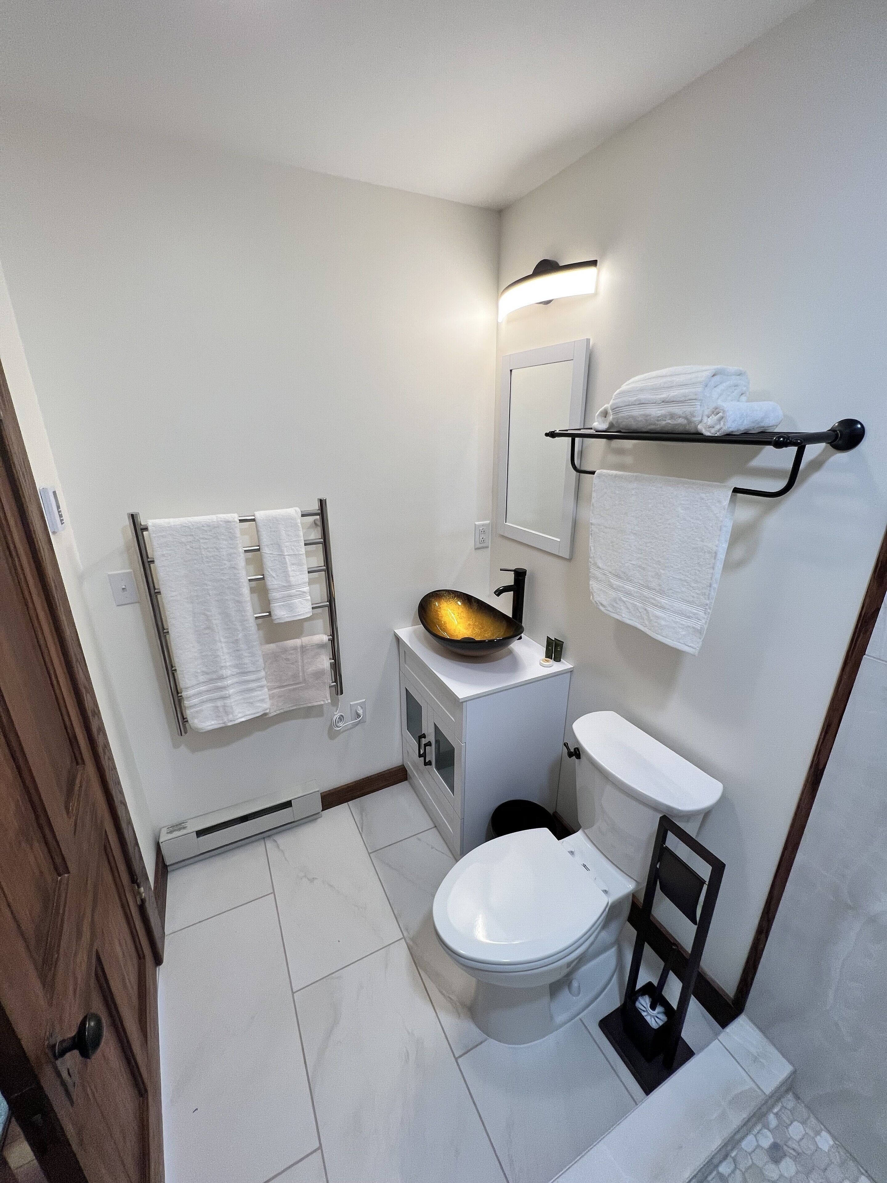 Ein kleines Badezimmer mit Toilette, Waschbecken und Handtuchhalter.