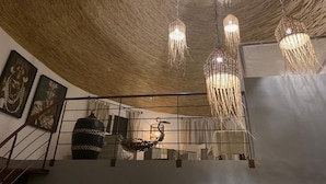 A room with a woven ceiling, a staircase, and a hanging light fixture. - Villa 88 Safari Village, Saly (Saly)