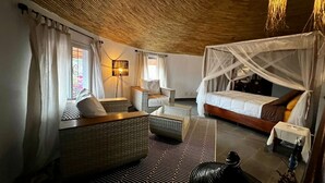 A room with a bed, a sofa, a chair, a lamp, and a window with curtains. - Villa 88 Safari Village, Saly (Saly)