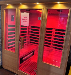 A red-lit sauna with a sign instructing to remove shoes. - Charming Retreat in the Heart of Watkins Glen (Watkins Glen)