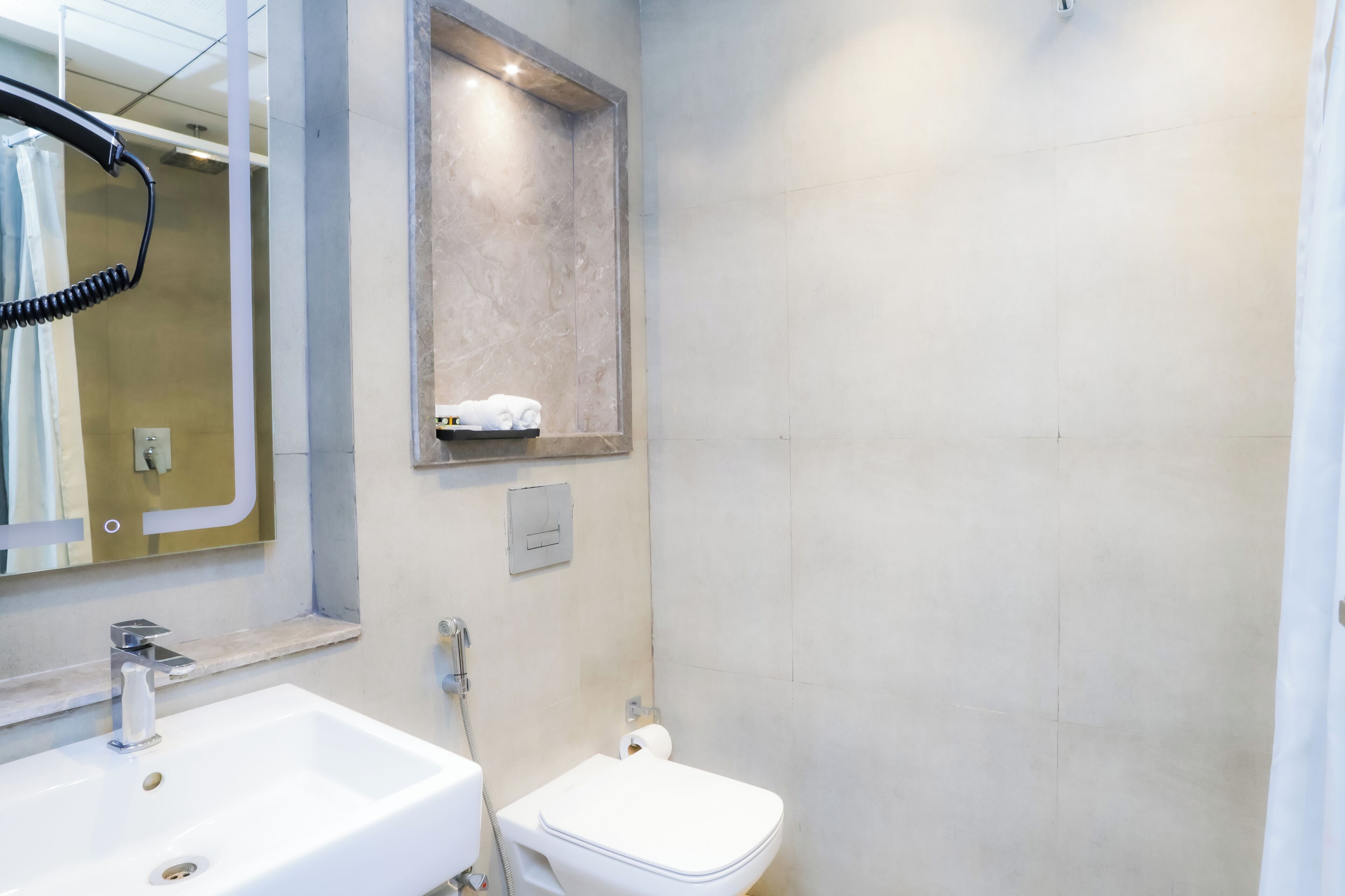 A bathroom with a white sink, a toilet, and a shower area.