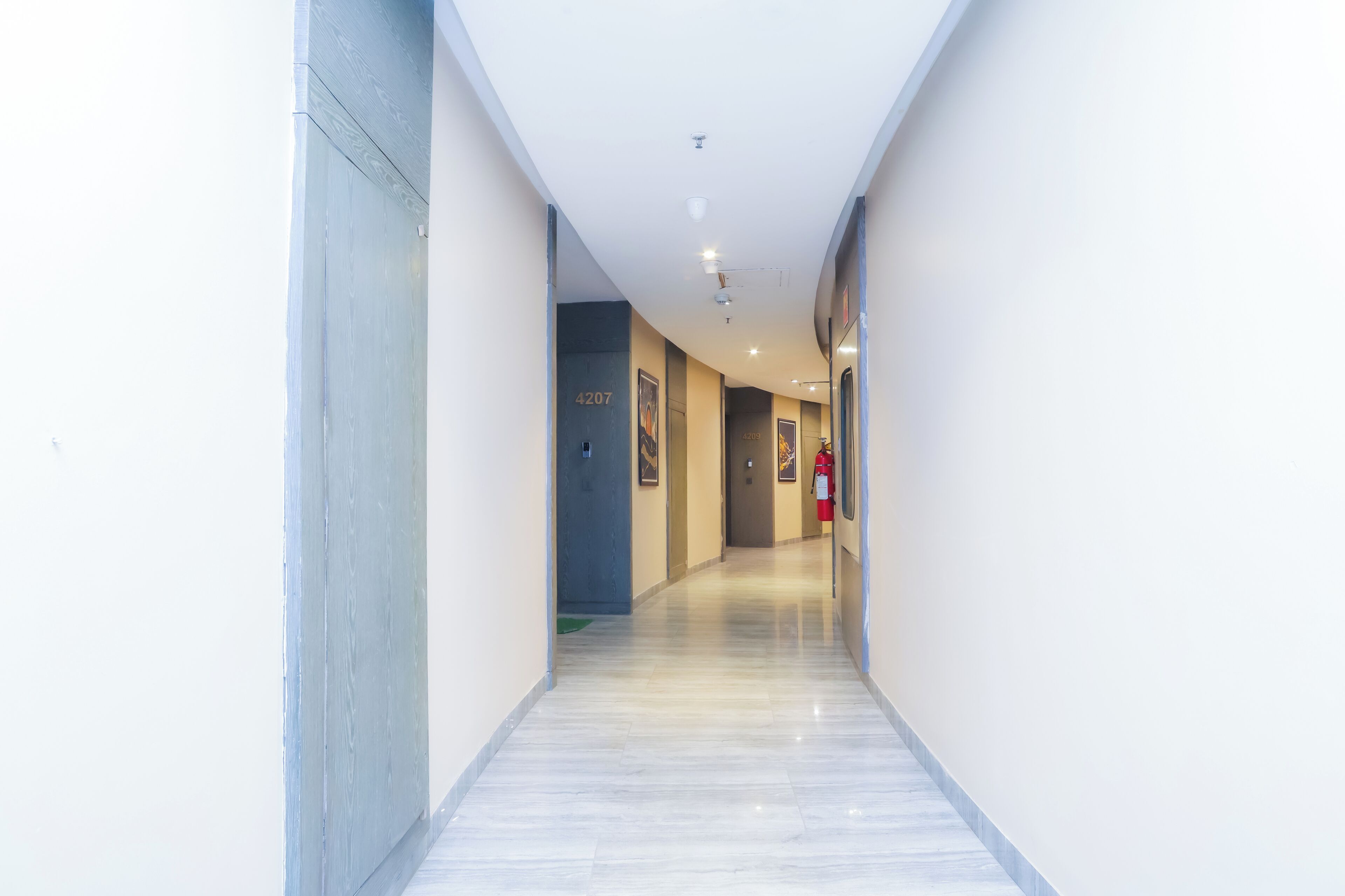 A corridor with a marble floor, white walls, and doors numbered 4207 and 4208.