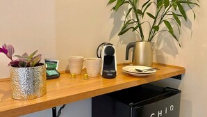 Un comptoir de cuisine avec une machine à café, une plante et une poubelle portant l’inscription « CHIR ».