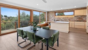Una cocina moderna con una isla grande, suelo de madera y vistas al exterior.