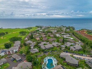 An aerial view of a residential area with houses, a swimming pool, and a golf course. - Mauna Kai · Delightful views of Pool & Mountains Princeville (Princeville)