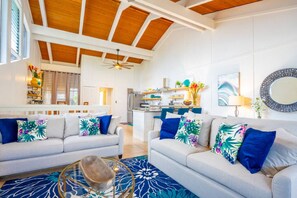 A modern living room with two sofas, a coffee table, and a kitchen in the background.