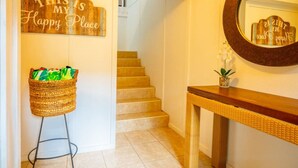 Eine Treppe führt zu einer zweiten Etage, ein Korb voller Gegenstände und ein Spiegel an der Wand.