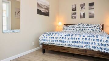 Een slaapkamer met een houten bed, een spiegel en wanddecoratie.
