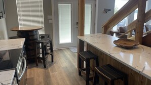 A kitchen with a wooden countertop, a stove, and a bar area with stools. - Luxury Main Channel Lake House, Dock, Party Bar (Rocky Mount)