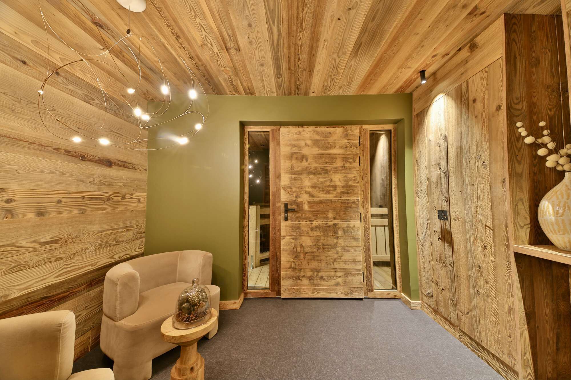 Un intérieur en bois avec un canapé, une petite table et une porte.